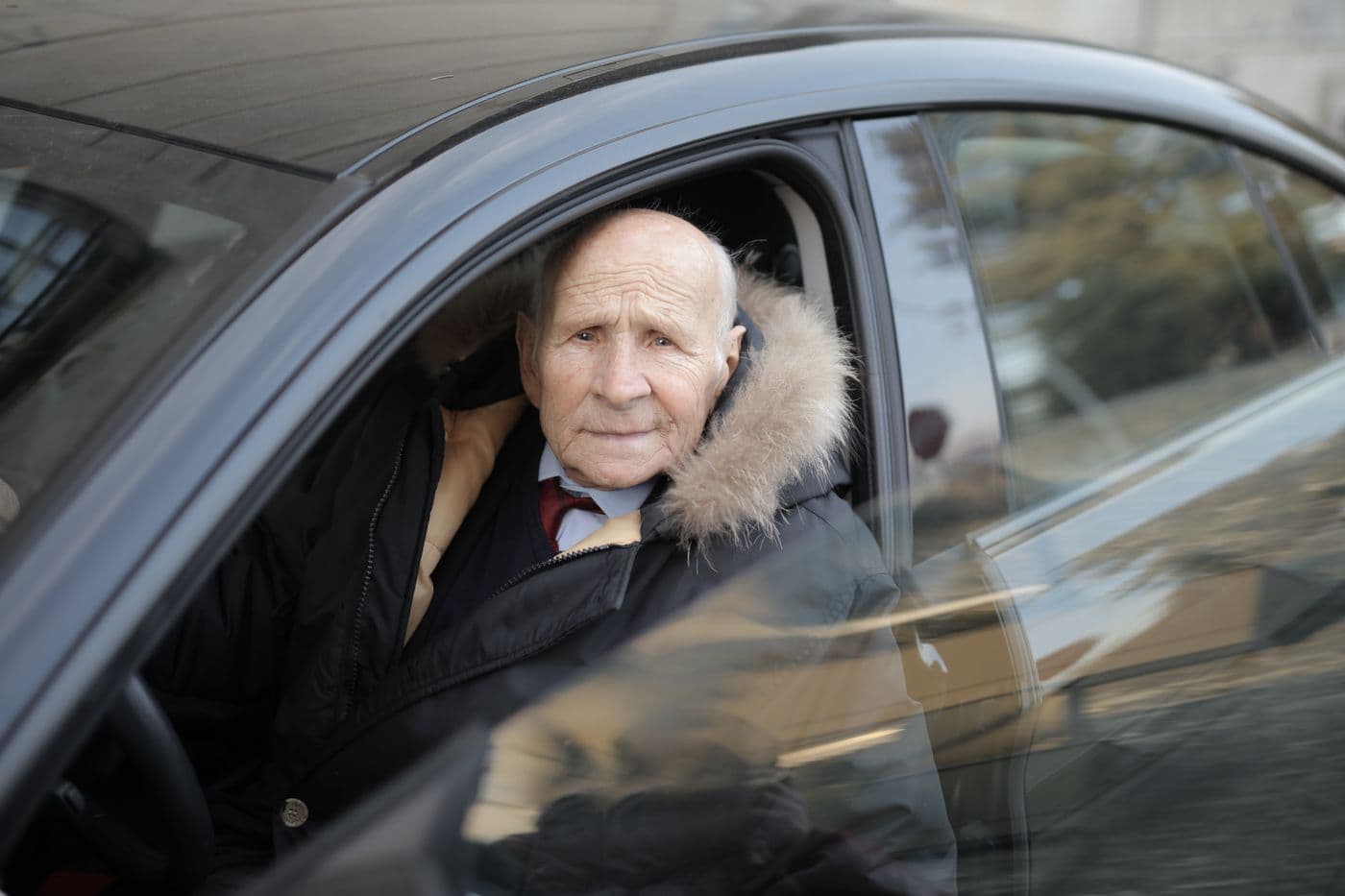 An older adult seated safely in a vehicle